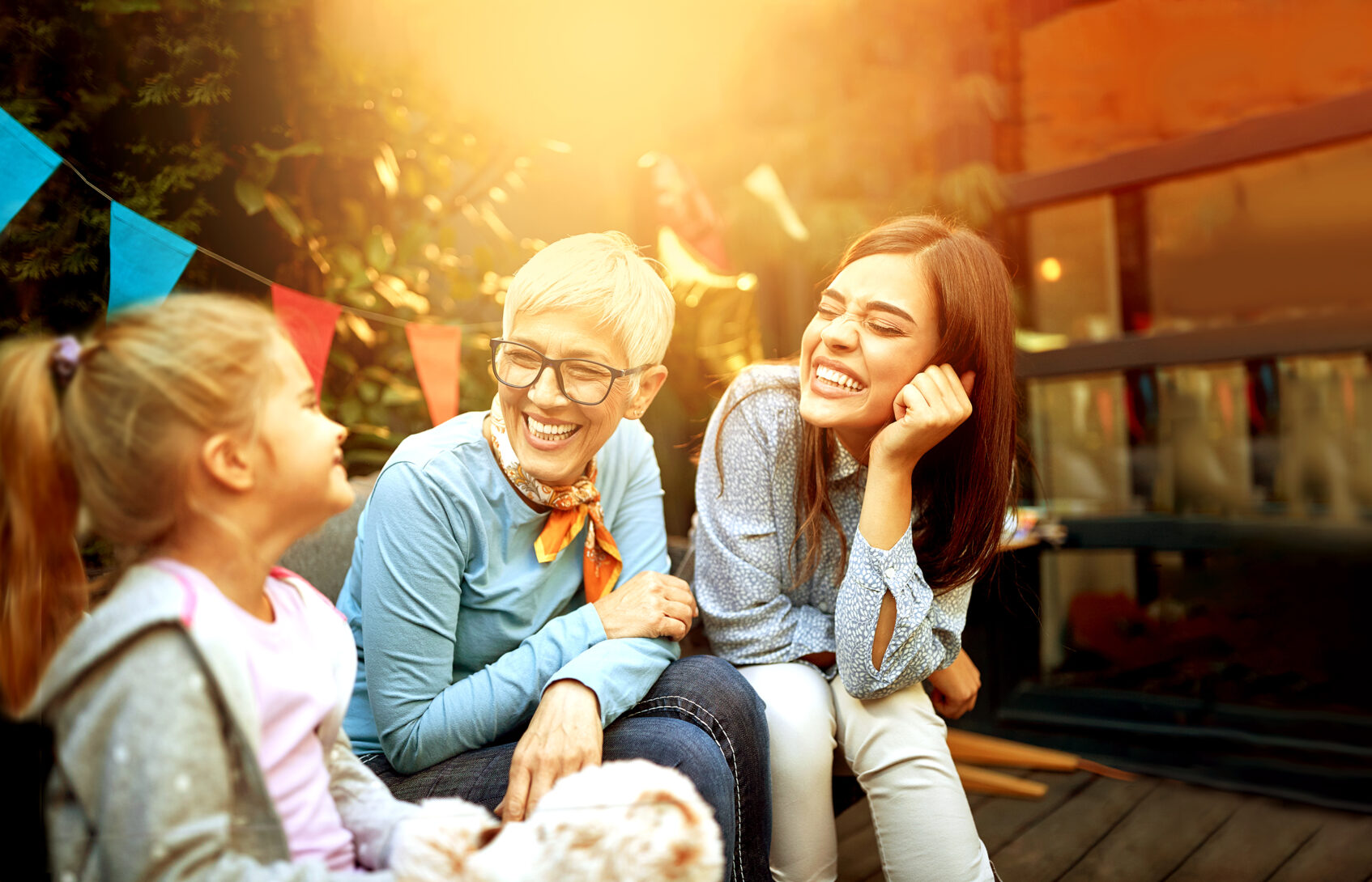 Laughing grandmother sitting between her two smiling grand daughters