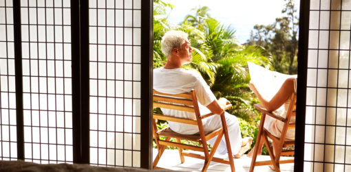 A man and a woman sitting in chairs on their outdoor patio