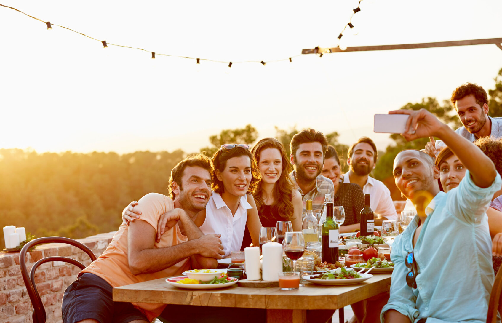 Friends take a selfie while having dinner outdoors