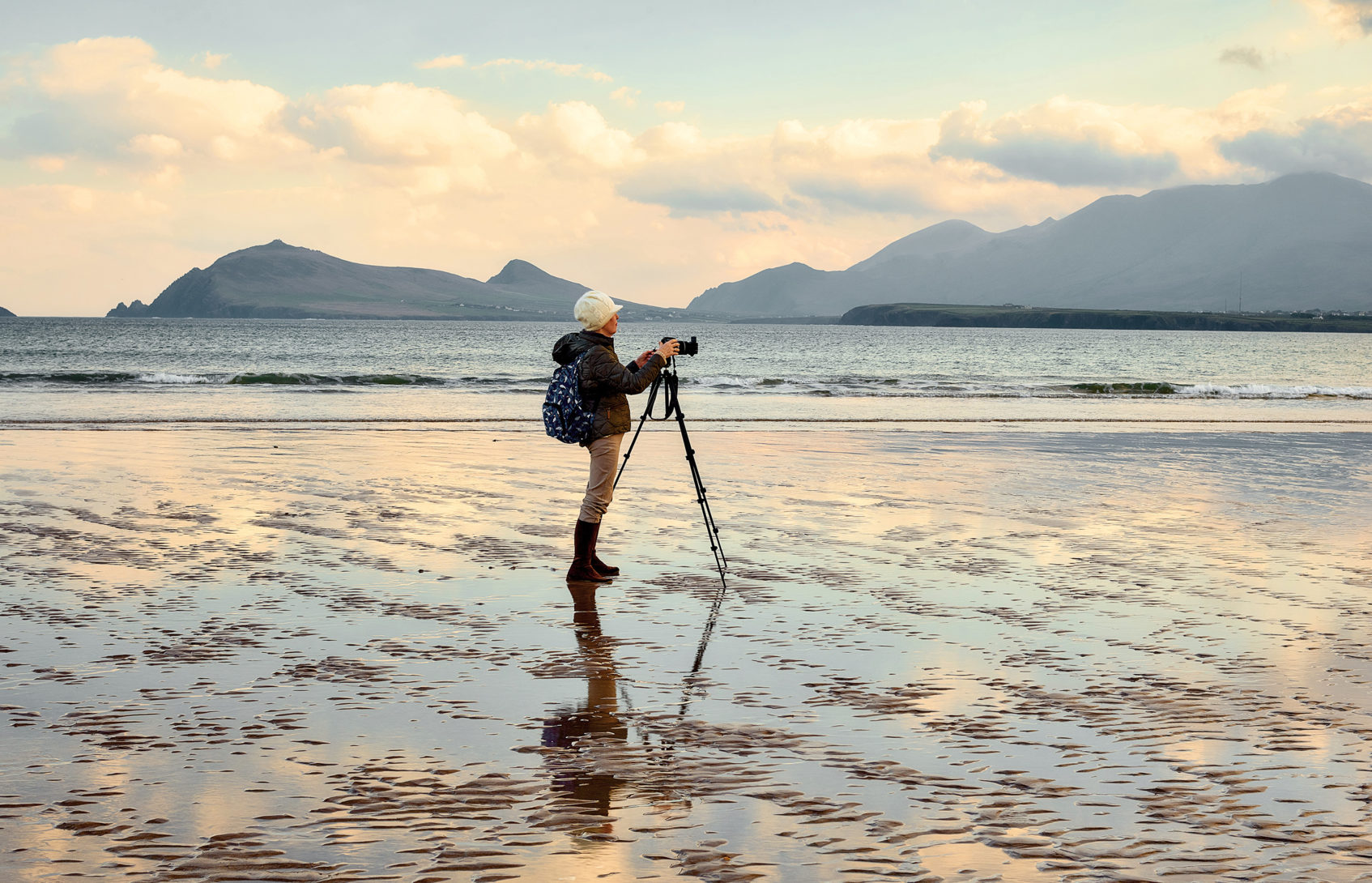 A woman on a beach taking photos