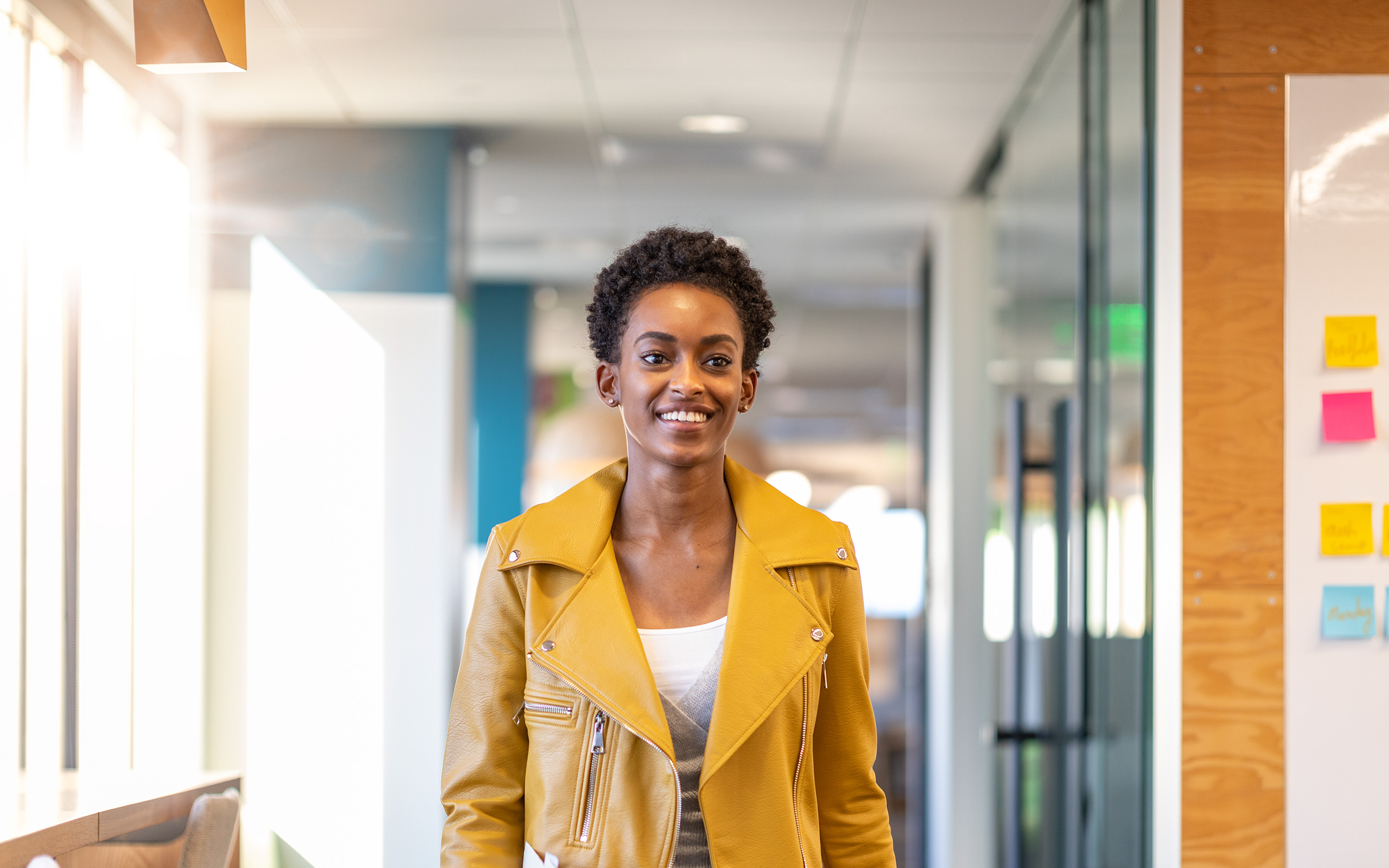 A business person walks confidently through an office hallway