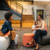 Two women sit and discuss plans