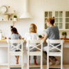 A mom and her two young daughters sitting in chairs at a table