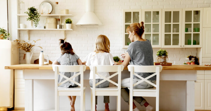 A mom and her two young daughters sitting in chairs at a table
