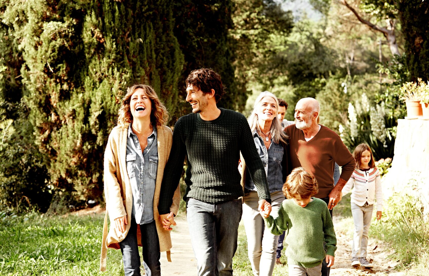 A multigeneration family walking down a path
