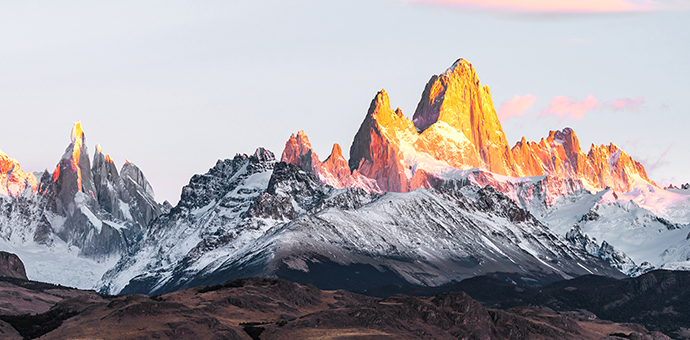 The sun shines on mountain peaks near route 40 in Argentina.
