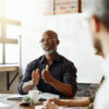 A man addressing a team of people in a meeting