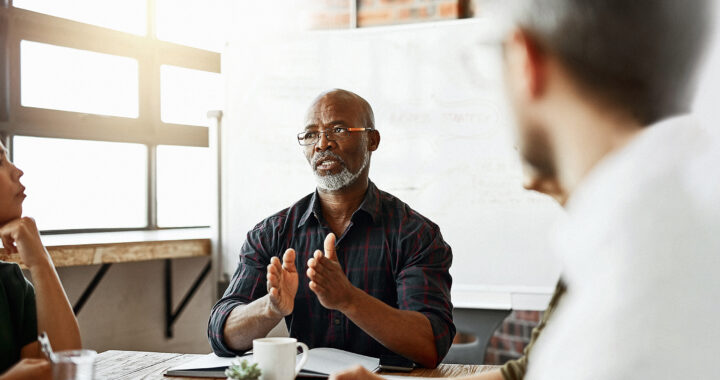 A man addressing a team of people in a meeting