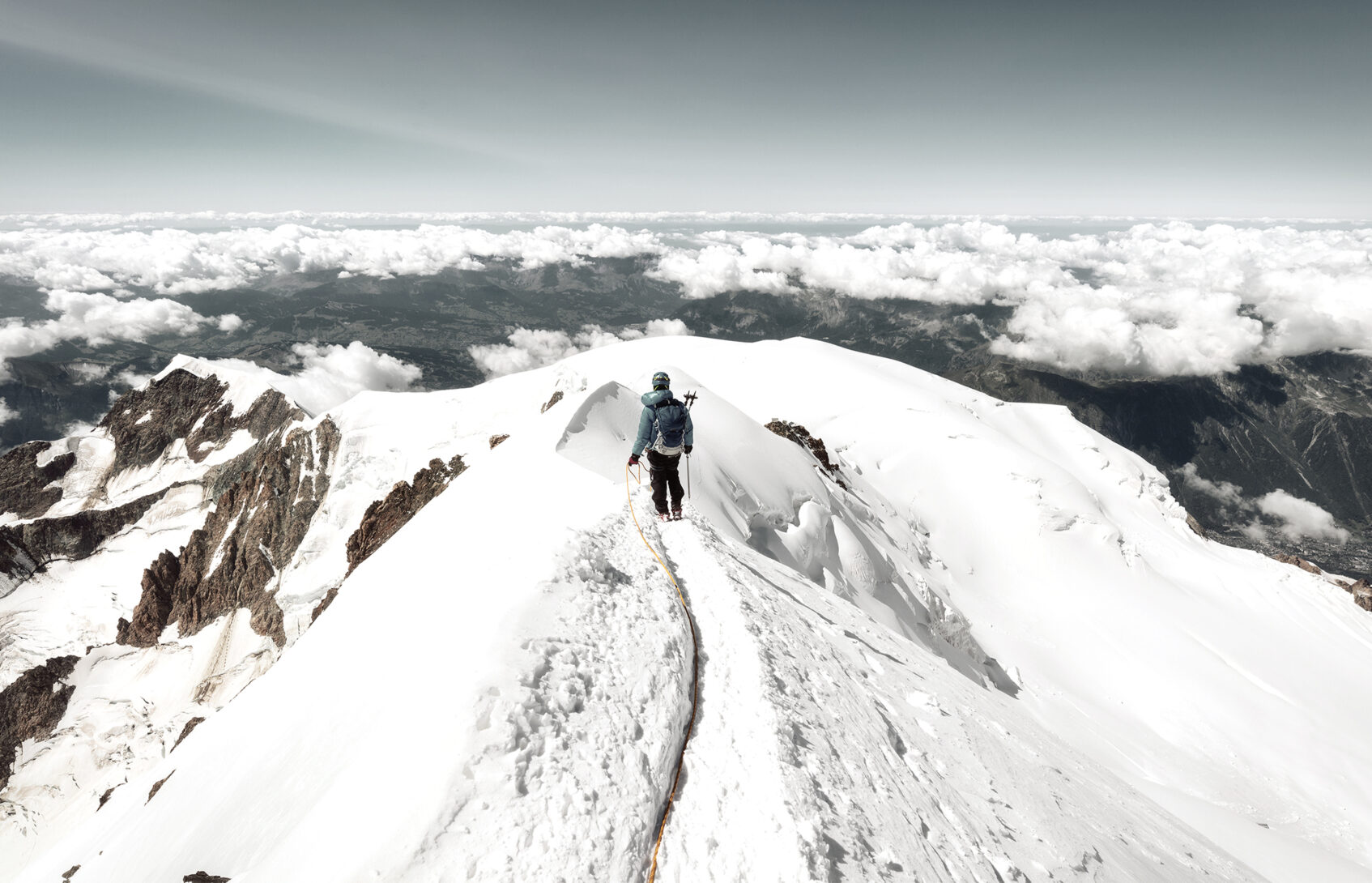 Mountaineer trekking to the top of Mont Blanc mountain in French Alps.