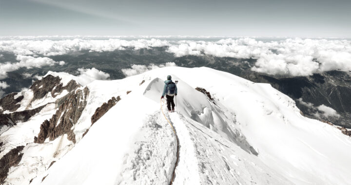 Mountaineer trekking to the top of Mont Blanc mountain in French Alps.