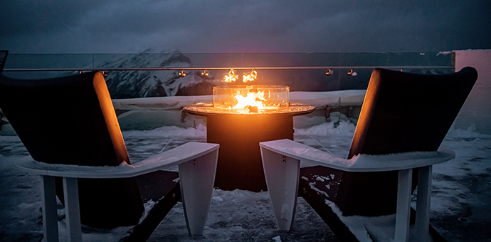 Outdoor lounging area with a fireplace in the wintertime.