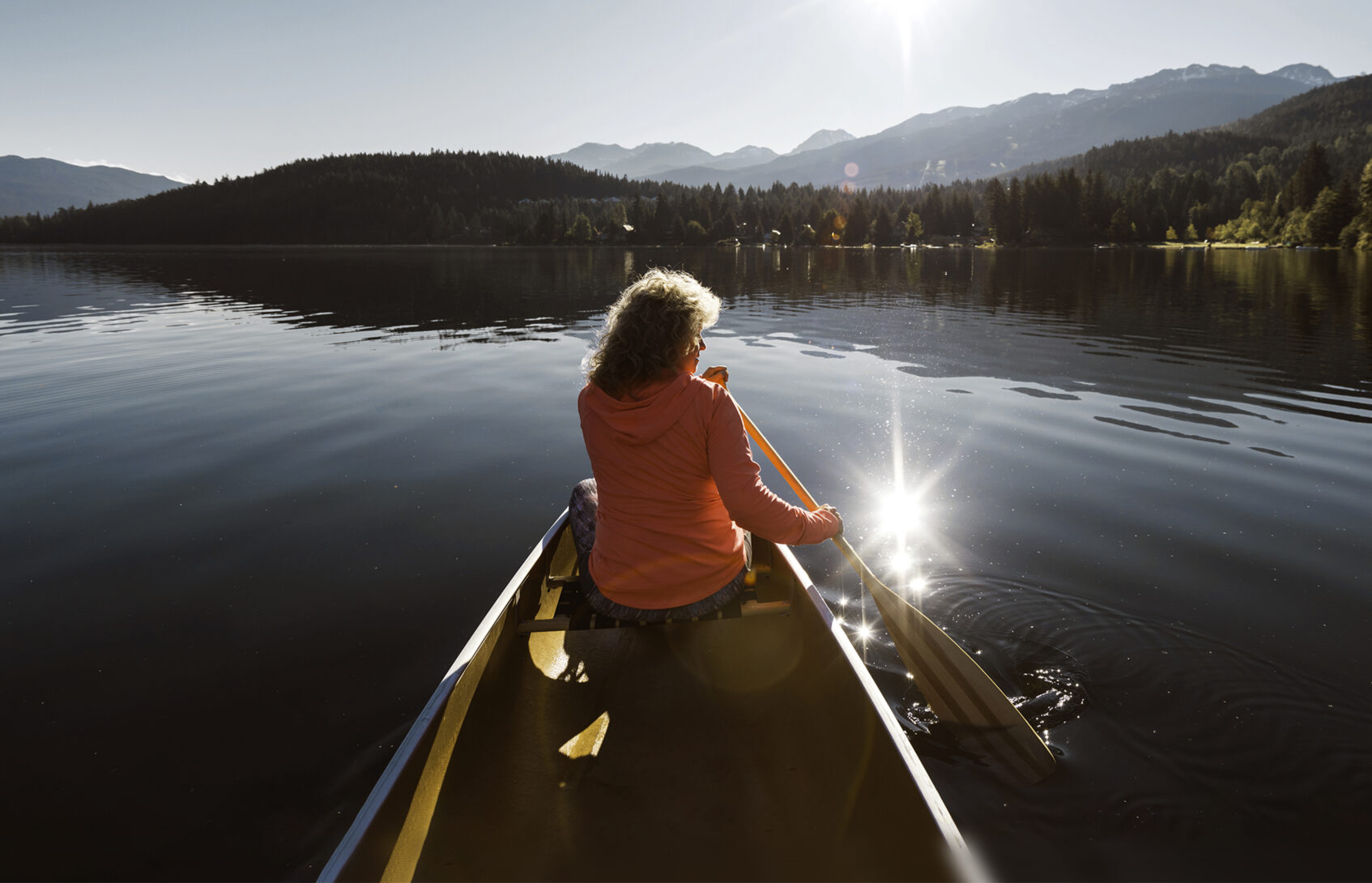 Senior aged woman canoeing in the lake.