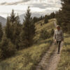 Woman walks down trail in the morning.