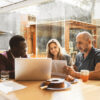 A couple sitting at a table with a financial advisor reviewing documents.