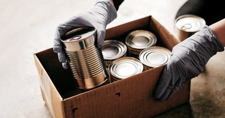 Volunteer preparing donation boxes with cans at the food bank