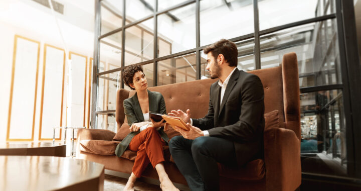 A woman and man reviewing documents while seated next to each other.