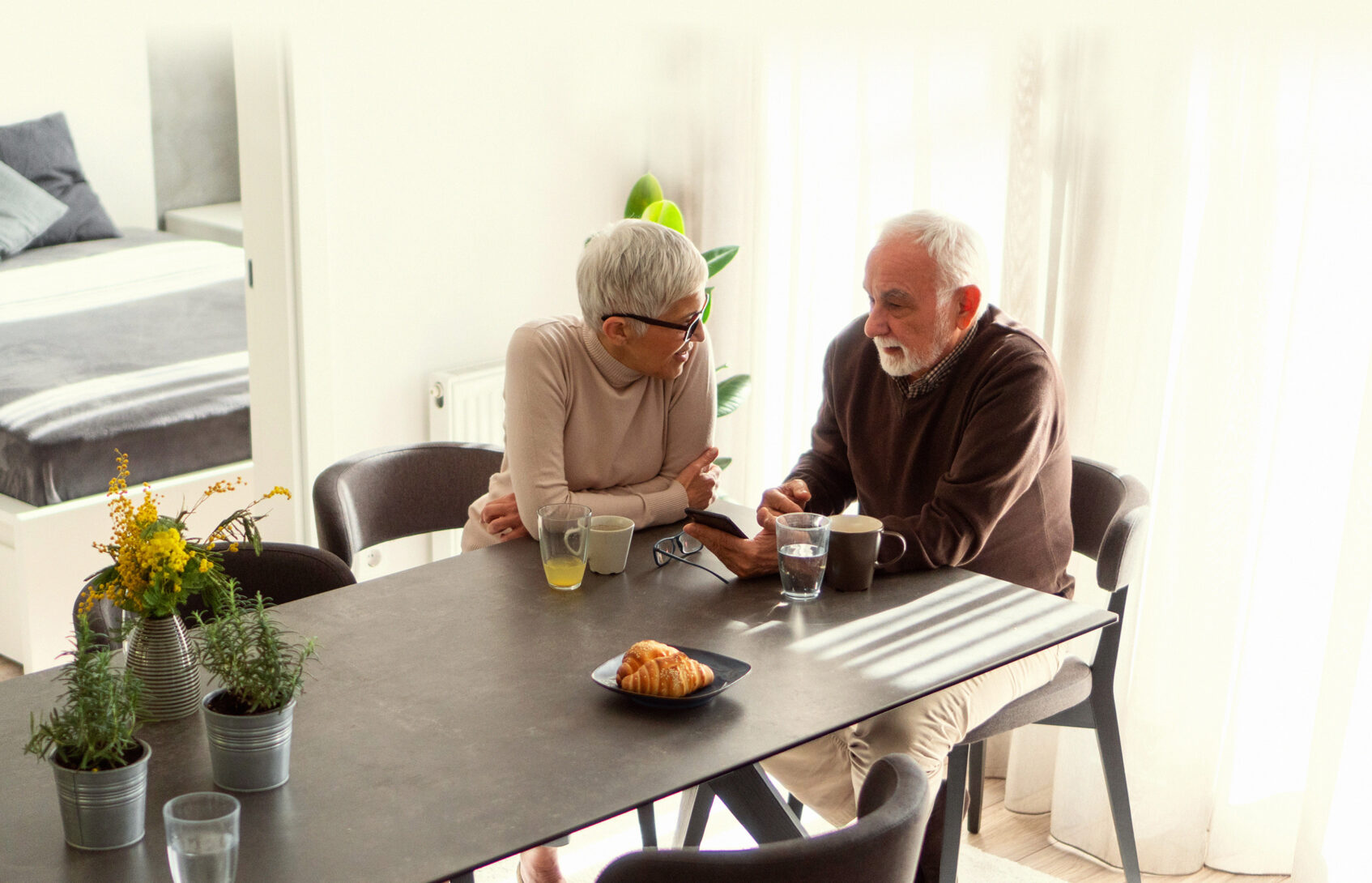 A man and woman sit together at a table talking