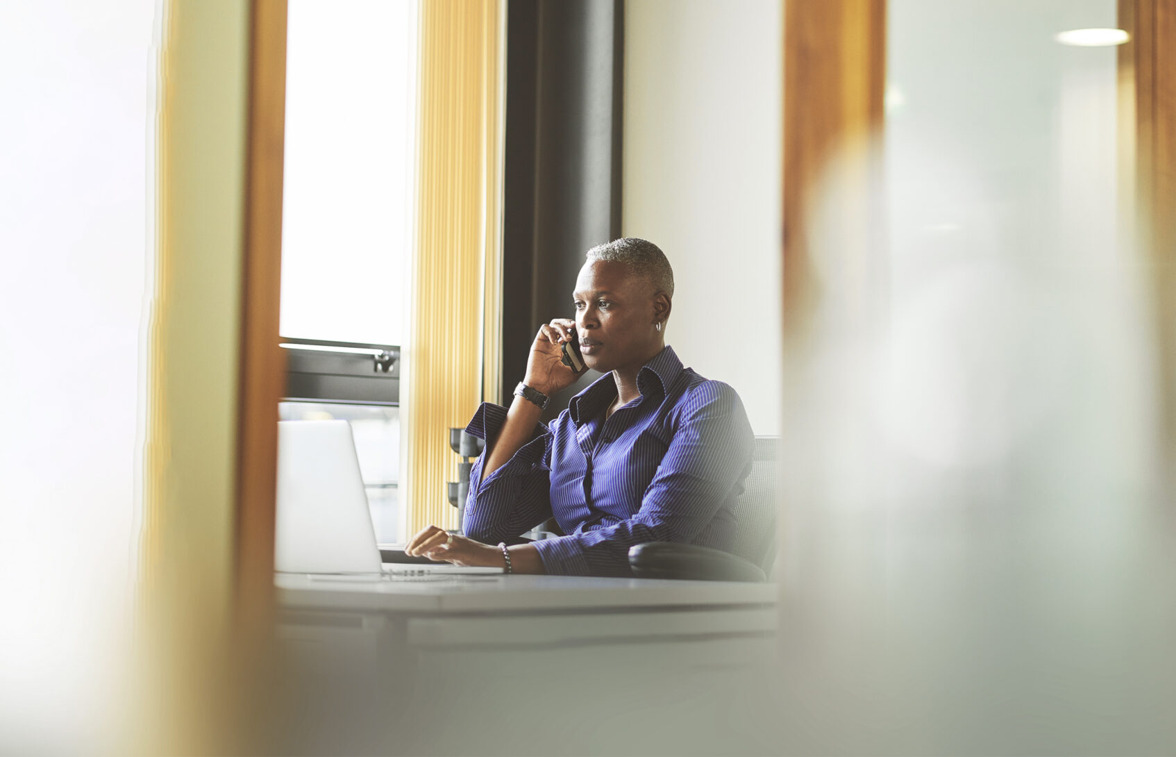Woman seated at her desk with phone in hand